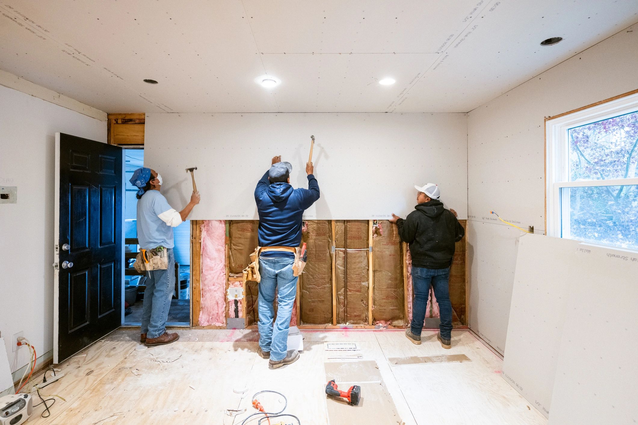 Drywall installers working in a residential kitchen renovation